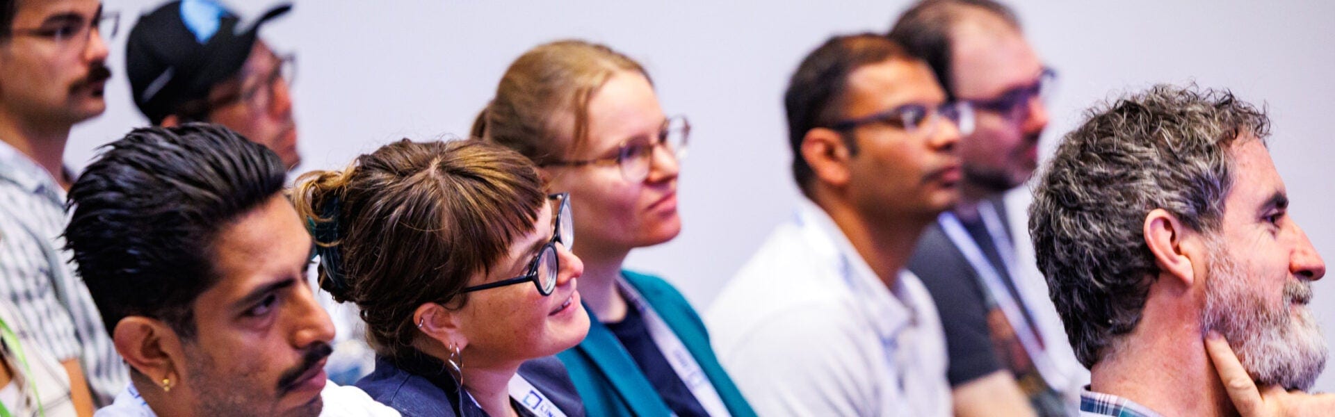 Attendees sitting in a room, listening intently.