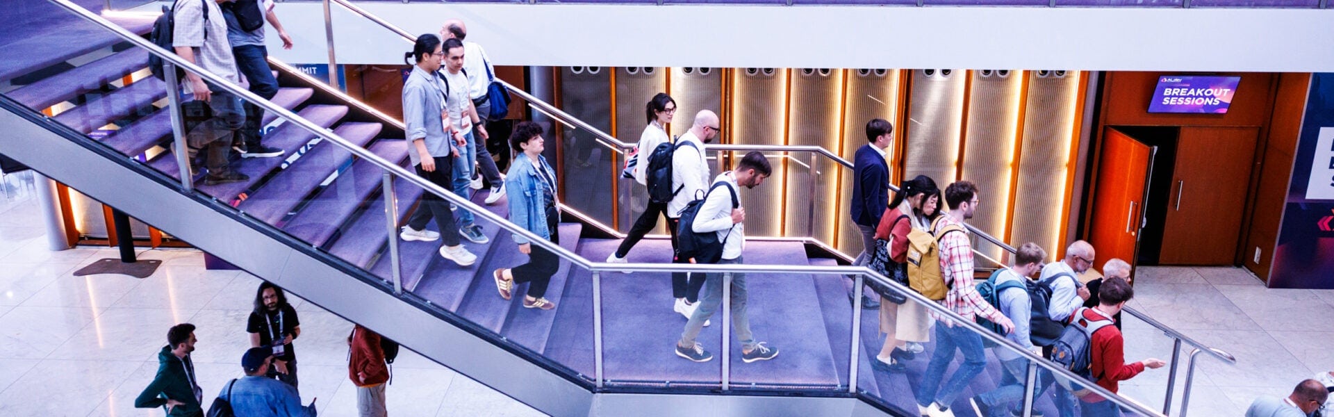 A crowd of people walking down a staircase.