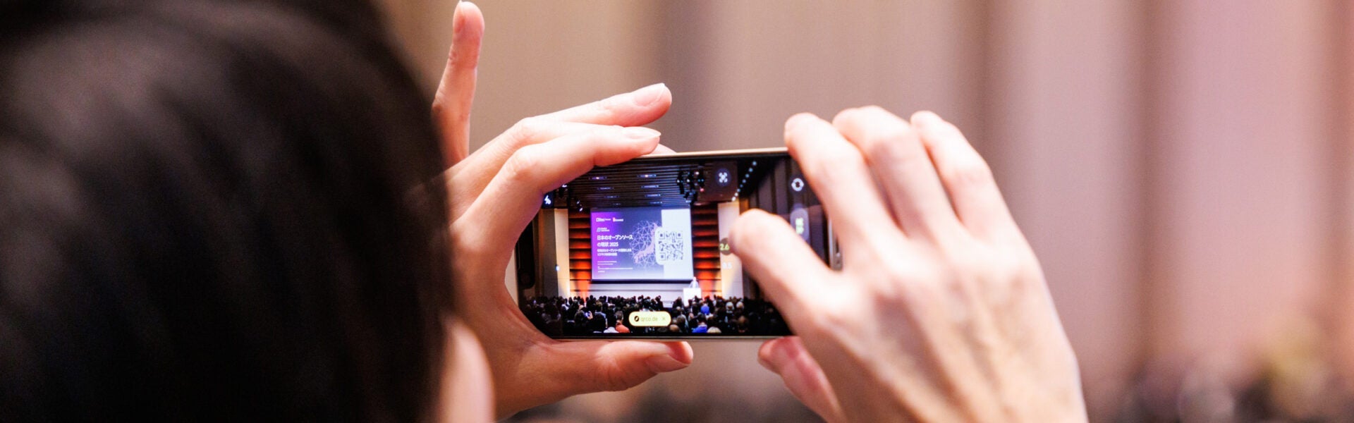 An attendee taking a photo on their phone.