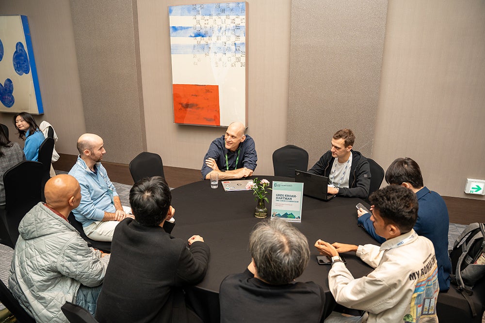 Small group seated around a table in discussion during a breakout session
